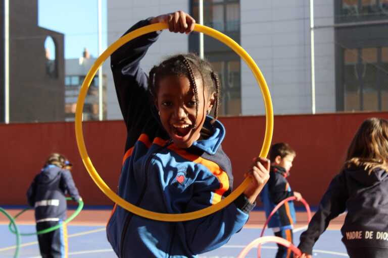 niña jugando aro patio colegio